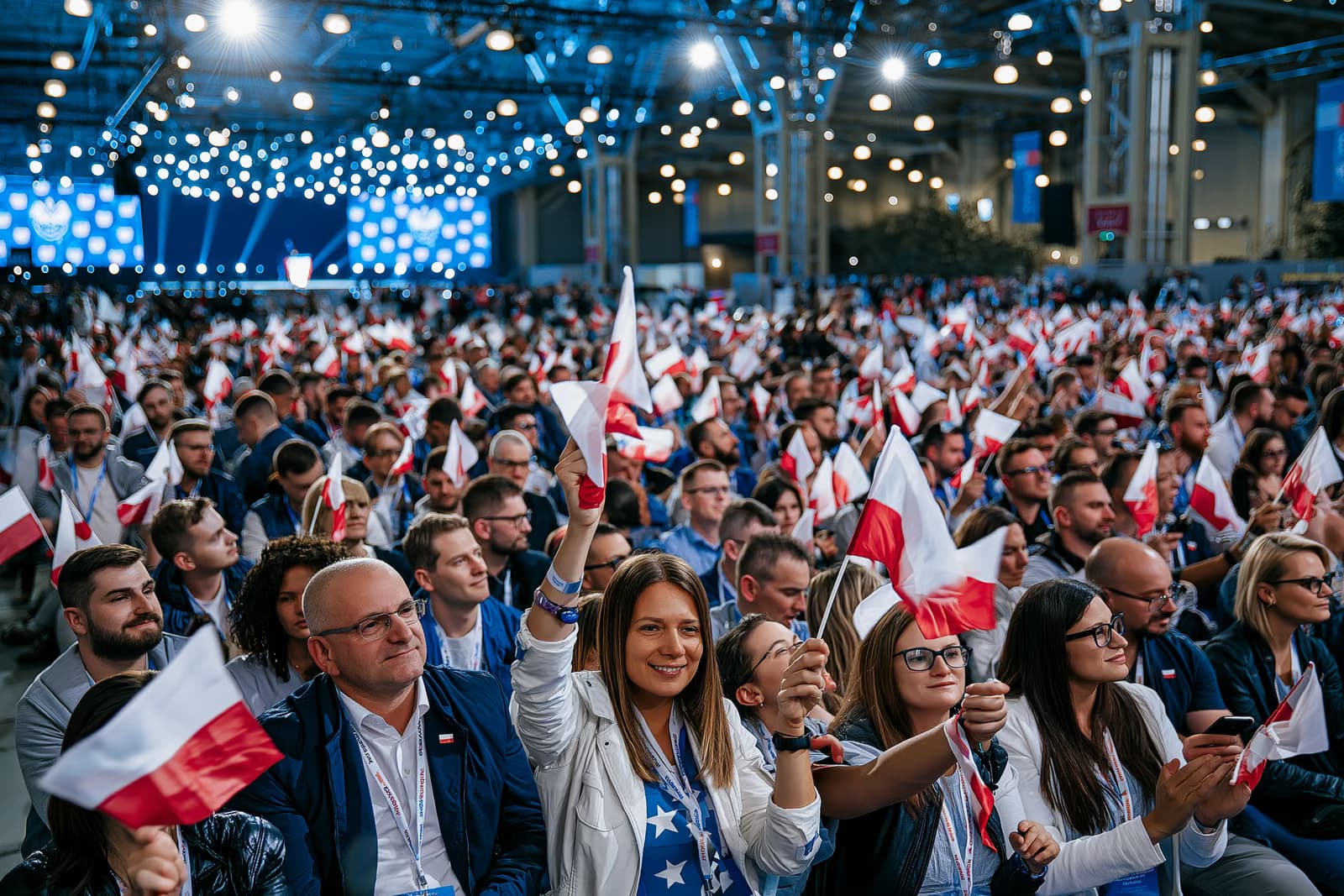 Per AfD kampanijos atidarymą Magdeburge, kurio metu pilna parodų salės minia, ryškiame renginio apšvietime mojuoja mažomis vėliavėlėmis, o tolumoje matosi scena.