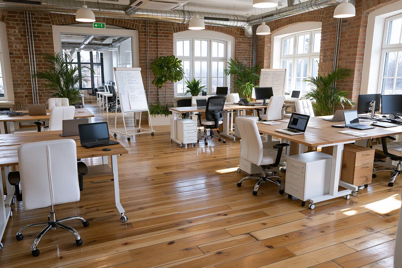 Įkūrėjai dirba kartu prie stalų moderniame vokiško startuolio biure.